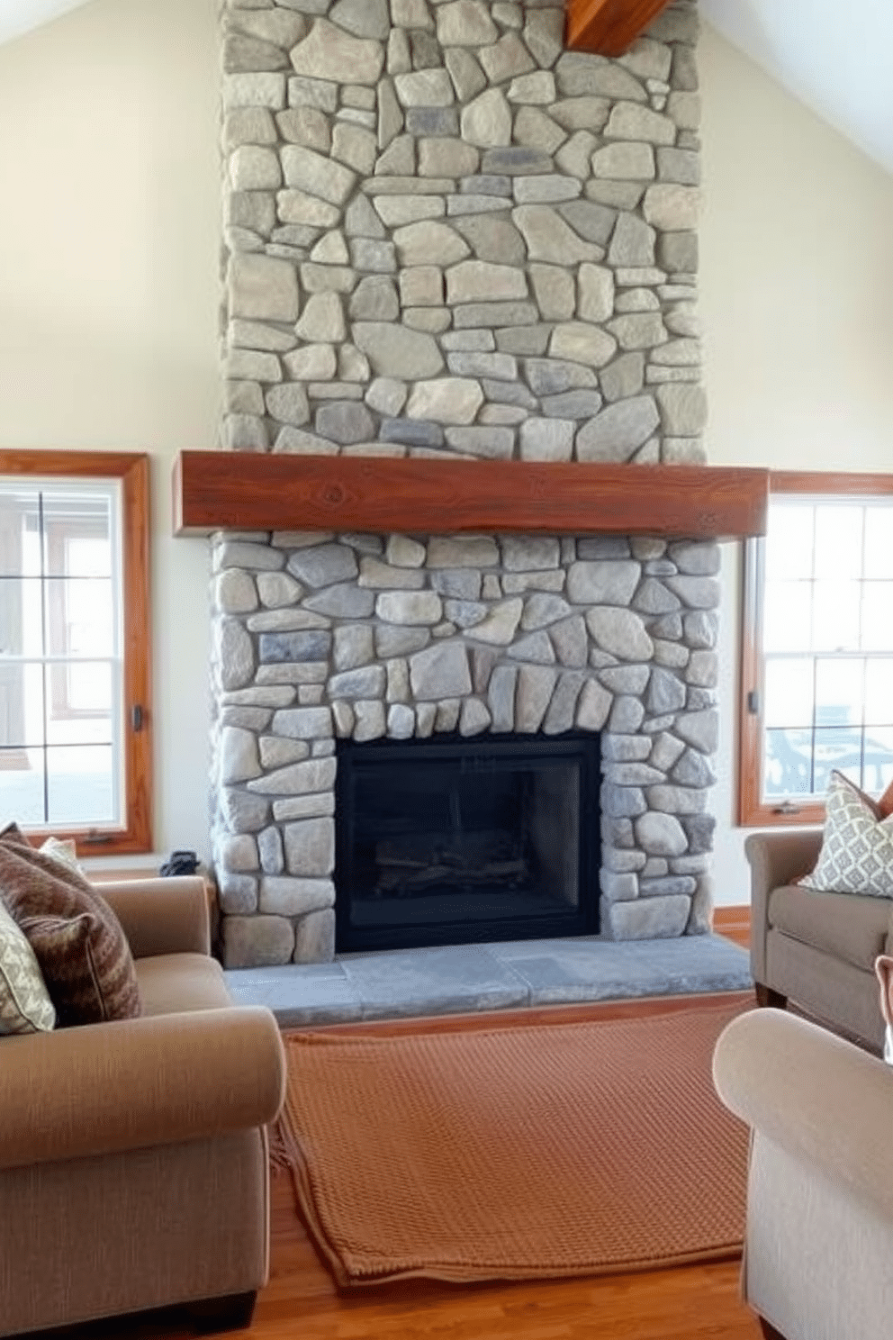 A rustic stone fireplace serves as the focal point of the family room, its textured surface contrasting beautifully with the warm wooden mantel above. Surrounding the fireplace, plush seating in earthy tones invites relaxation, while a woven area rug adds warmth to the hardwood floor.