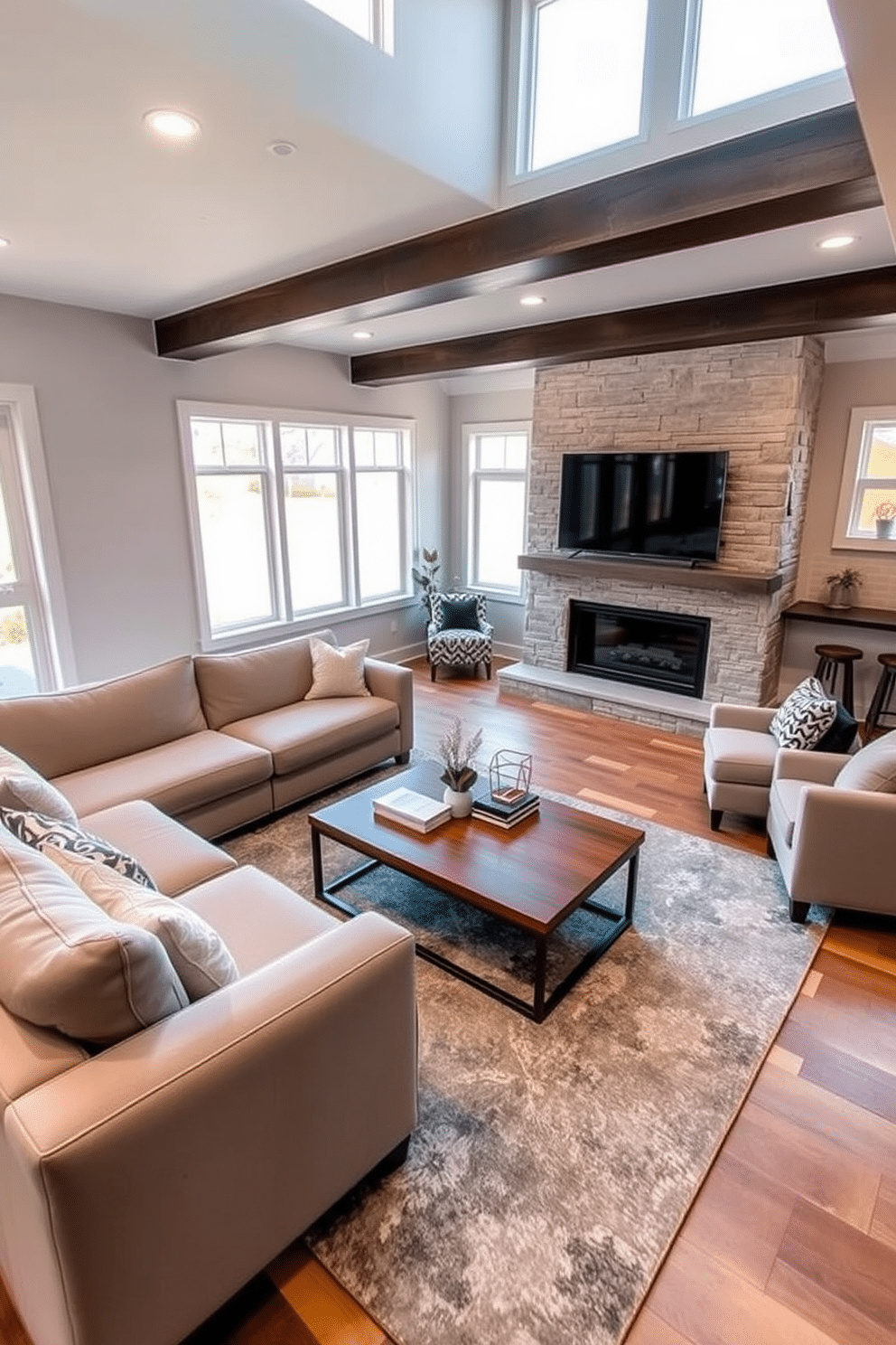 Open concept family room with fireplace. The space features a large sectional sofa in a soft gray fabric, facing a modern stone fireplace with a sleek mantel. Natural light floods the room through expansive windows, highlighting a stylish area rug that anchors the seating arrangement. A wooden coffee table sits at the center, adorned with decorative books and a small potted plant. Finished basement design ideas. The basement is transformed into a cozy entertainment area with a plush sectional and a large flat-screen TV mounted on the wall. Soft recessed lighting creates an inviting atmosphere, while a small kitchenette in the corner includes a bar with stools for casual gatherings.