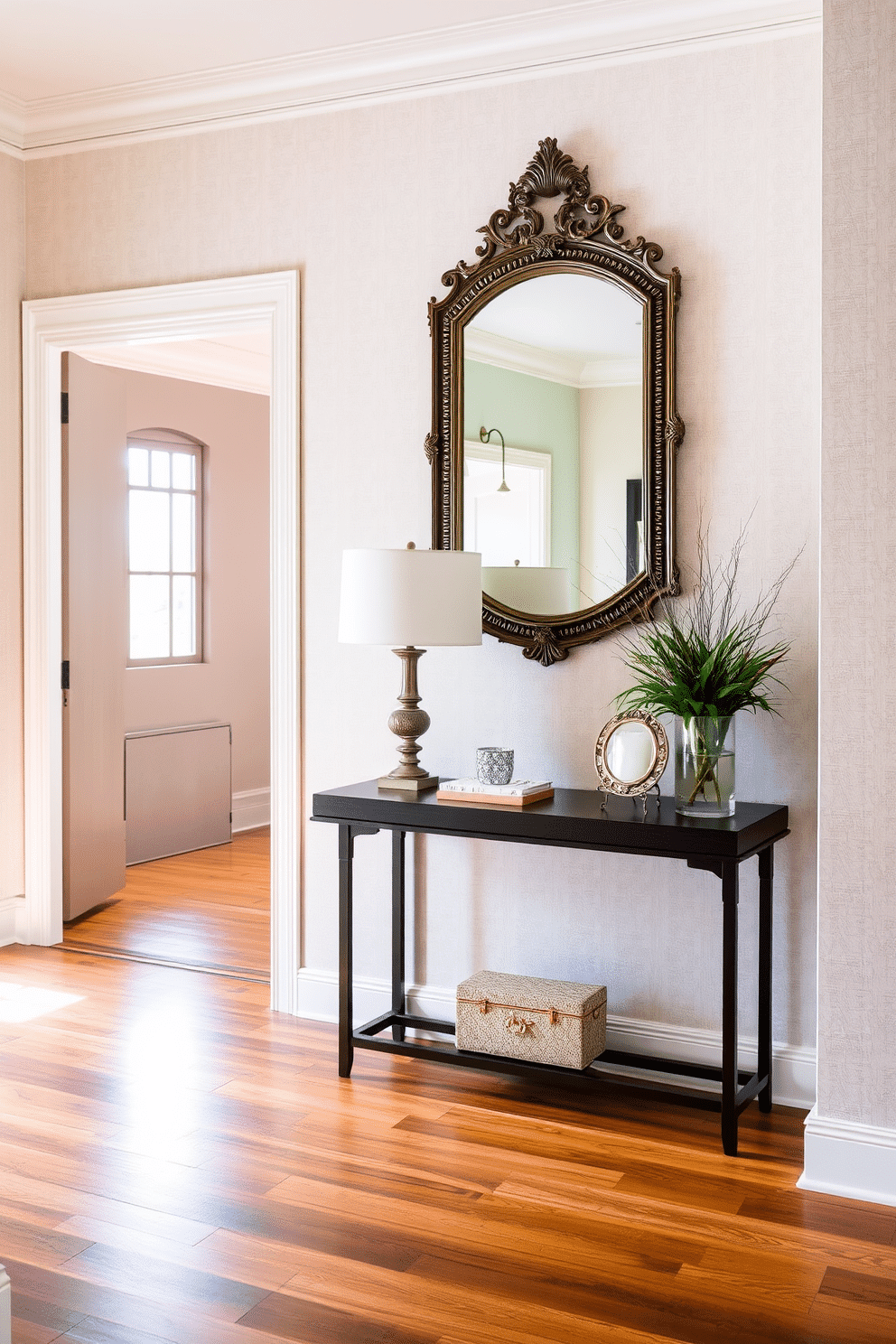 A welcoming foyer featuring fabric wall panels that add softness and texture to the space. The panels are upholstered in a light, neutral fabric, creating a serene backdrop for a sleek console table adorned with decorative accents. The floor is adorned with a rich hardwood finish that complements the fabric panels beautifully. A statement mirror with an ornate frame hangs above the console, reflecting light and enhancing the foyer's inviting atmosphere.