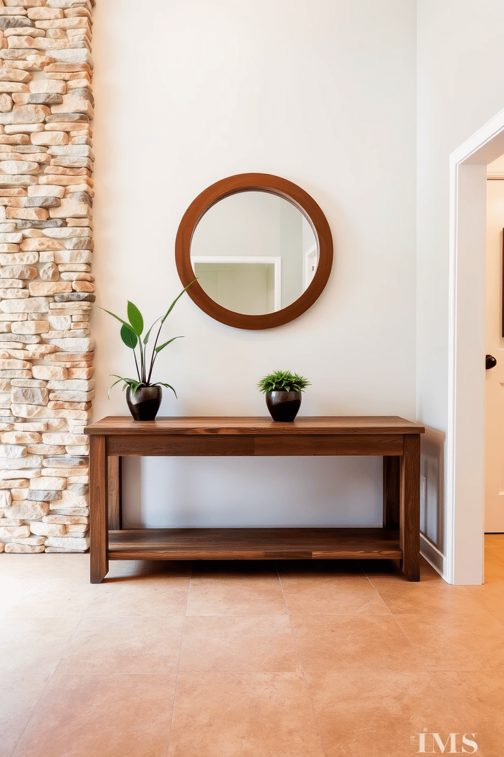 A serene foyer featuring a natural stone accent wall that exudes an earthy feel. The floor is adorned with large, textured tiles in warm tones, complemented by a rustic wooden console table against the wall. Above the console, an oversized round mirror with a wooden frame enhances the space, reflecting natural light. Potted greenery is placed on the table, adding a touch of life and vibrancy to the entrance.