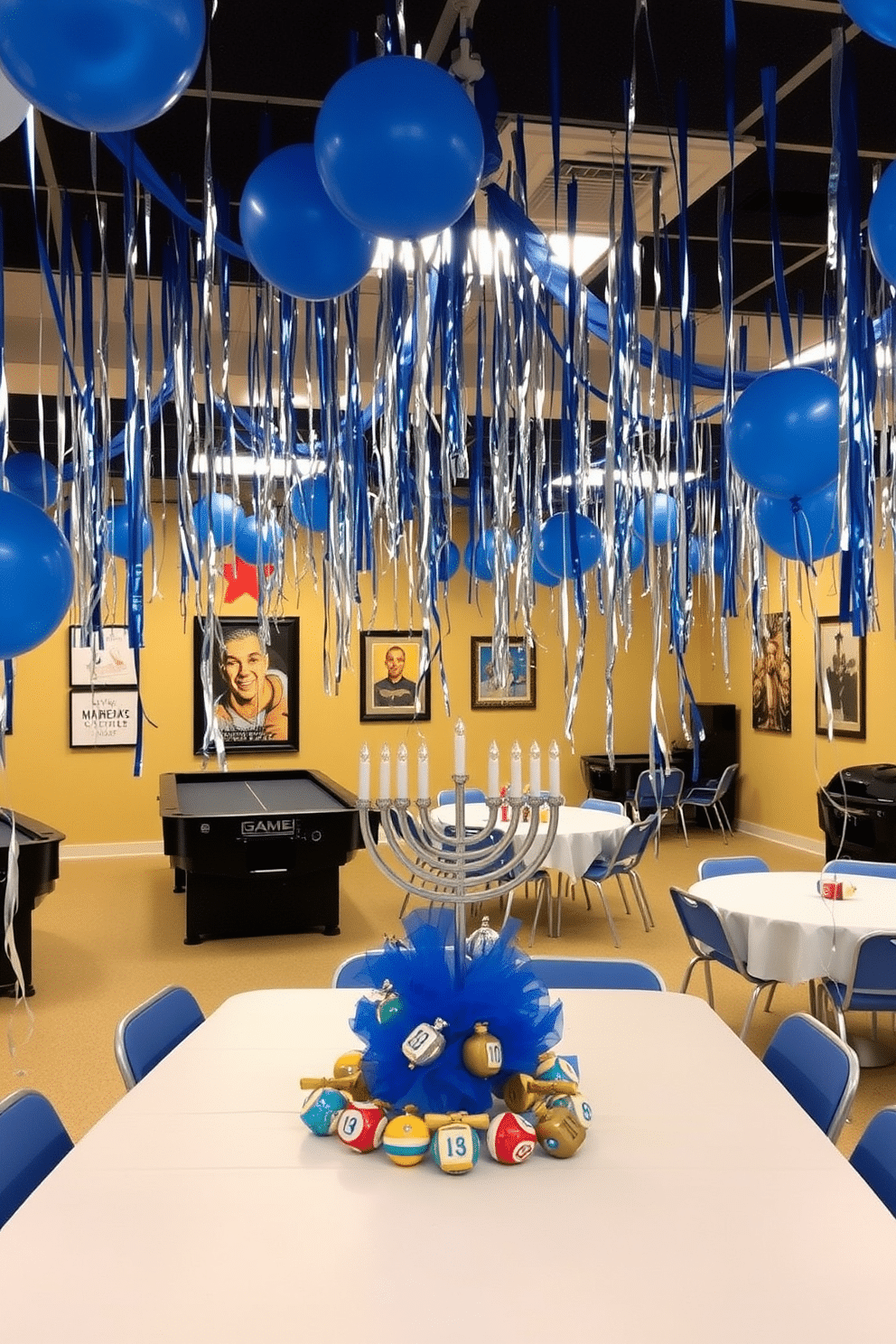 A vibrant game room decorated for Hanukkah, featuring blue and silver streamers cascading from the ceiling and balloons in various shades of blue floating around the space. The walls are adorned with festive wall art, and a large table is set up with a menorah centerpieces surrounded by dreidels and gelt, creating a joyful atmosphere for celebration.