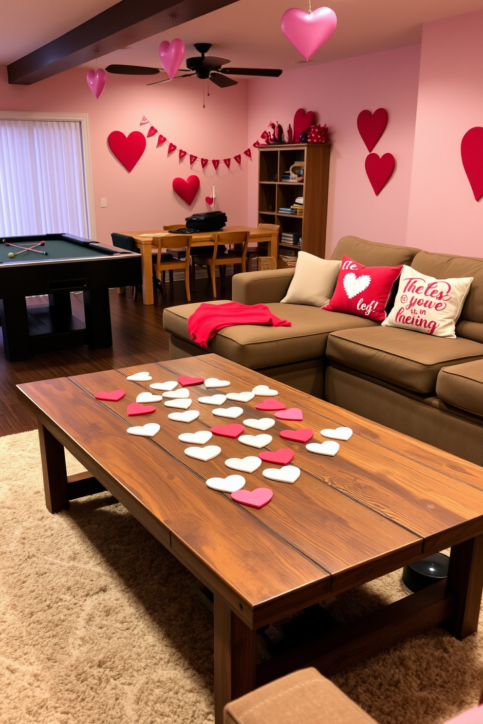 A cozy game room adorned for Valentine's Day features heart-shaped coasters scattered on a rustic wooden coffee table. The walls are decorated with soft pink and red accents, while a plush sectional sofa invites guests to relax and enjoy the festive atmosphere.