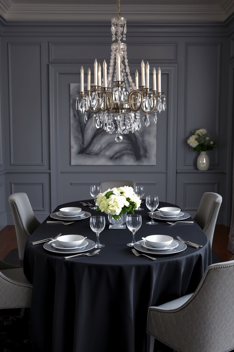 A sophisticated dining room featuring layered gray and black table settings. The table is elegantly set with a black tablecloth, gray dinnerware, and polished silver cutlery, complemented by crystal glassware that catches the light beautifully. The room is adorned with gray walls and a plush black rug that adds warmth to the space. A stunning chandelier hangs overhead, casting a soft glow on the carefully arranged place settings, while a centerpiece of white flowers brings a touch of freshness to the design.