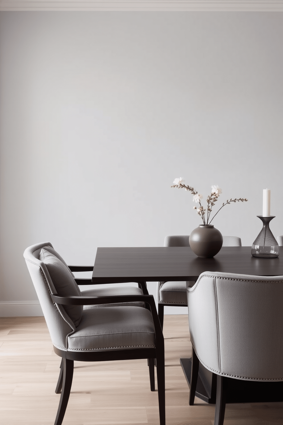 A stylish dining room featuring soft gray cushions on elegant dining chairs. The walls are painted in a light gray tone, complemented by a sleek, modern dining table made of dark wood.