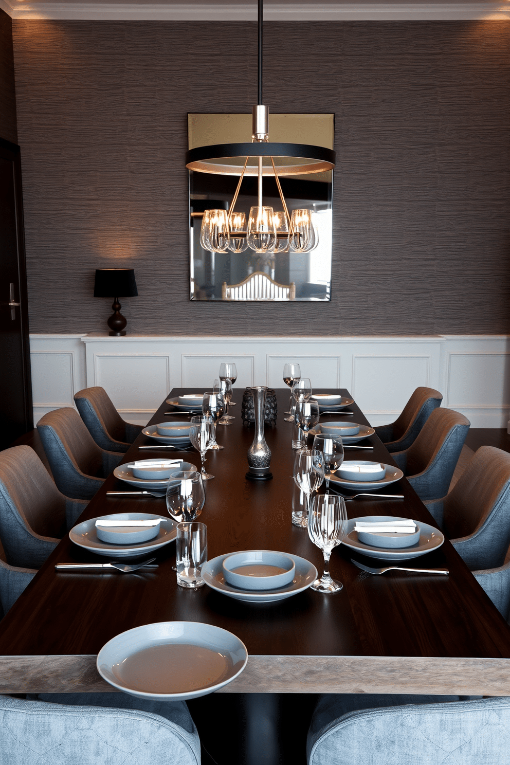 A refined dining room featuring a long, dark wood table set with gray ceramic plates, complemented by sleek silver cutlery and crystal glassware. Soft, ambient lighting from a modern chandelier casts a warm glow, enhancing the sophisticated atmosphere of the space. The walls are adorned with textured gray wallpaper, creating a subtle backdrop for the elegant decor. Plush gray upholstered chairs surround the table, inviting guests to enjoy a luxurious dining experience.