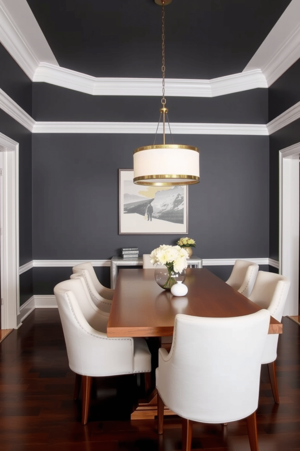 A stylish dining room featuring dark gray walls contrasted by crisp white trim. The space includes a sleek wooden dining table surrounded by plush upholstered chairs in a light fabric, complemented by a statement chandelier overhead.