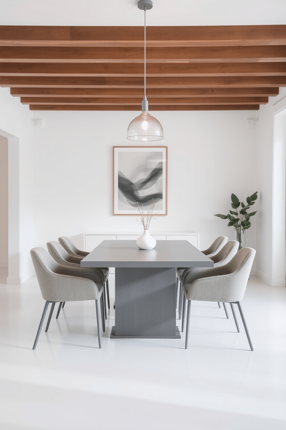 A minimalist gray dining set with clean lines sits elegantly in the center of a bright, airy dining room. The table features a sleek, rectangular shape, complemented by modern, upholstered chairs that enhance the room's serene atmosphere. The walls are painted in a soft white hue, creating a perfect contrast with the gray furniture. A simple pendant light hangs above the table, casting a warm glow and adding a touch of sophistication to the space.