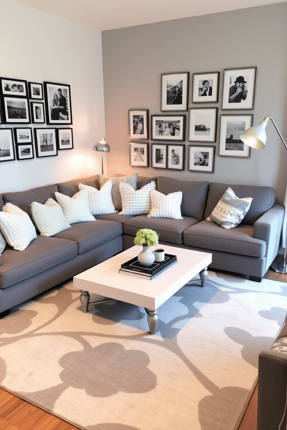 A stylish family room featuring an eclectic mix of gray and white decor. The space includes a plush gray sectional sofa adorned with a variety of textured white and gray throw pillows, complemented by a sleek white coffee table at the center. On one wall, a gallery of framed black-and-white photographs adds a personal touch, while a large, abstract gray and white rug anchors the seating area. A modern floor lamp with a sculptural design stands beside the sofa, illuminating the room with a warm glow.