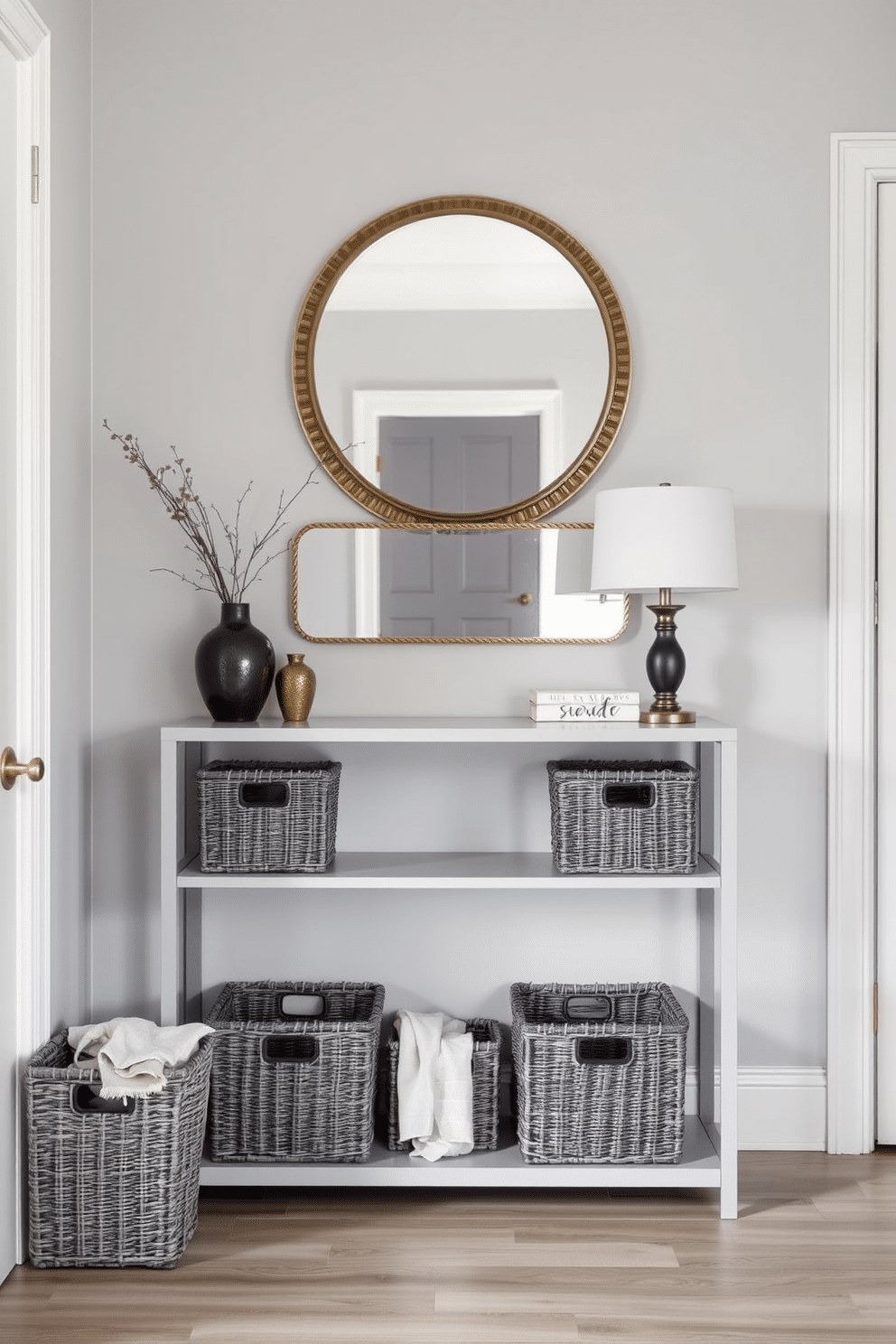 A chic foyer featuring gray woven baskets for stylish storage. The space is adorned with a sleek console table against a soft gray wall, complemented by a decorative mirror above it.