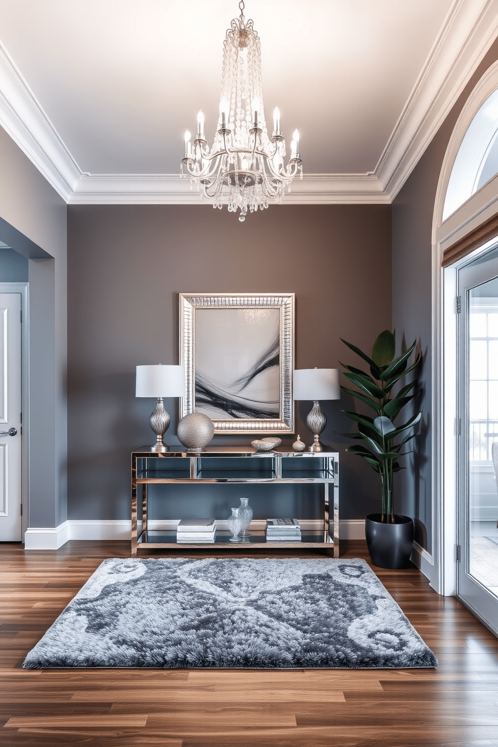 A luxurious foyer featuring a sleek gray color palette with silver accents. The space is illuminated by a stunning chandelier, while a plush gray area rug anchors the room beneath a stylish console table adorned with decorative silver accessories. The walls are painted in a soft gray hue, creating a sophisticated backdrop for elegant artwork. A large mirror with a silver frame reflects light and enhances the sense of space, while a statement potted plant adds a touch of greenery to the design.