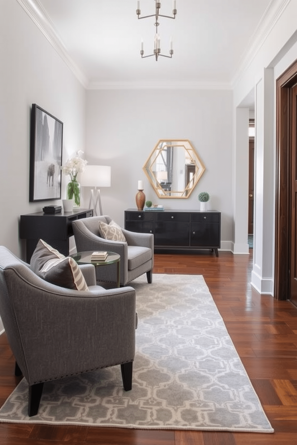 A stylish foyer featuring gray upholstered chairs that invite relaxation and comfort. The walls are adorned with elegant artwork, and a sleek console table complements the seating area. The flooring is a polished hardwood, enhancing the warm ambiance of the space. A decorative area rug in soft tones adds texture and ties the design elements together.