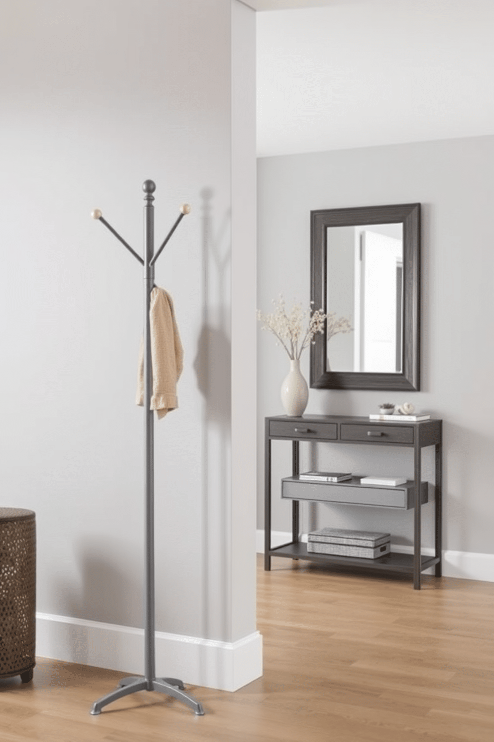 A functional gray coat rack stands elegantly near the entryway, designed with sleek lines and a minimalist aesthetic. The foyer features soft gray walls and a stylish console table beneath a large mirror, creating a welcoming and organized space.