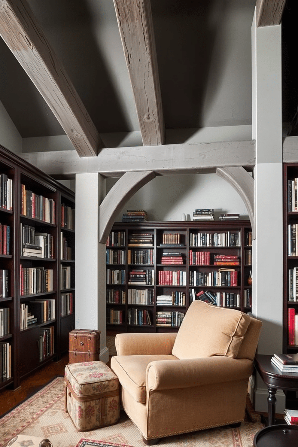 A cozy home library featuring rustic gray beams that add architectural interest to the space. The walls are lined with dark wooden bookshelves filled with an array of books, complemented by a plush, oversized armchair in a soft fabric.