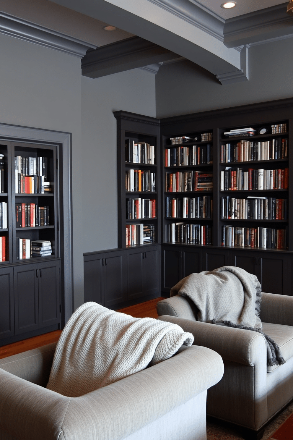 A cozy gray home library features plush seating with comfortable throw blankets draped over the armrests. The walls are lined with dark wooden bookshelves filled with an array of books, while soft lighting creates a warm and inviting atmosphere.