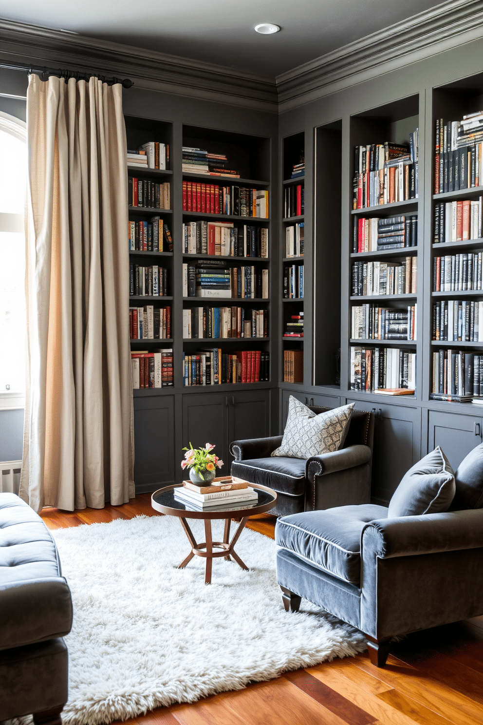 A cozy home library featuring a mix of textures, combining rich velvet upholstery on the seating and soft linen drapes framing the windows. The walls are painted in a deep gray, adorned with built-in bookshelves filled with a diverse collection of books, while a plush area rug adds warmth to the hardwood floor.