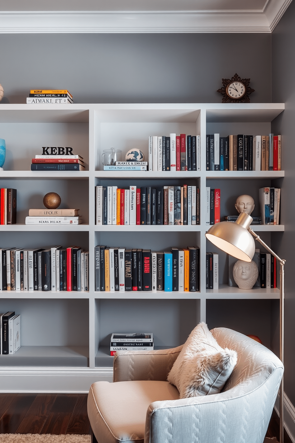 A modern home library featuring sleek floating shelves that display an array of books and decorative items. The walls are painted in a soft gray hue, complemented by a plush reading nook with a cozy armchair and a stylish floor lamp.