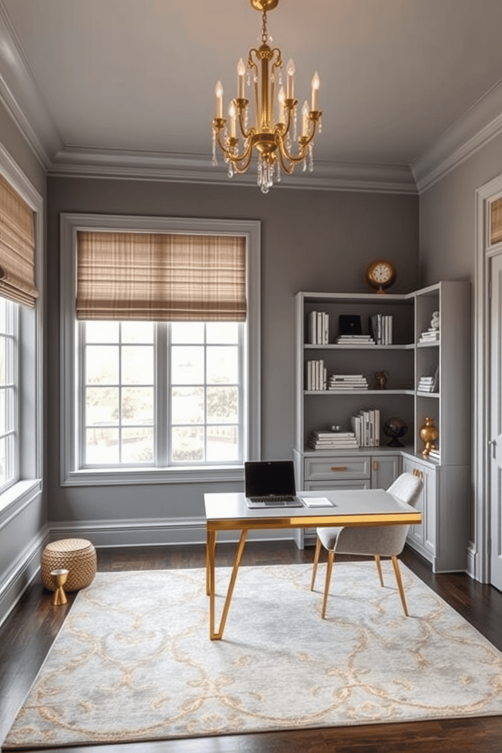 A chic home office featuring a gray and gold color scheme. The walls are painted in a soft gray, complemented by a sleek gold-accented desk and a plush chair with gold legs. Large windows allow natural light to flood the space, highlighting a stylish area rug with subtle gold patterns. Decorative shelves lined with books and elegant accessories add personality, while a statement gold chandelier hangs overhead.