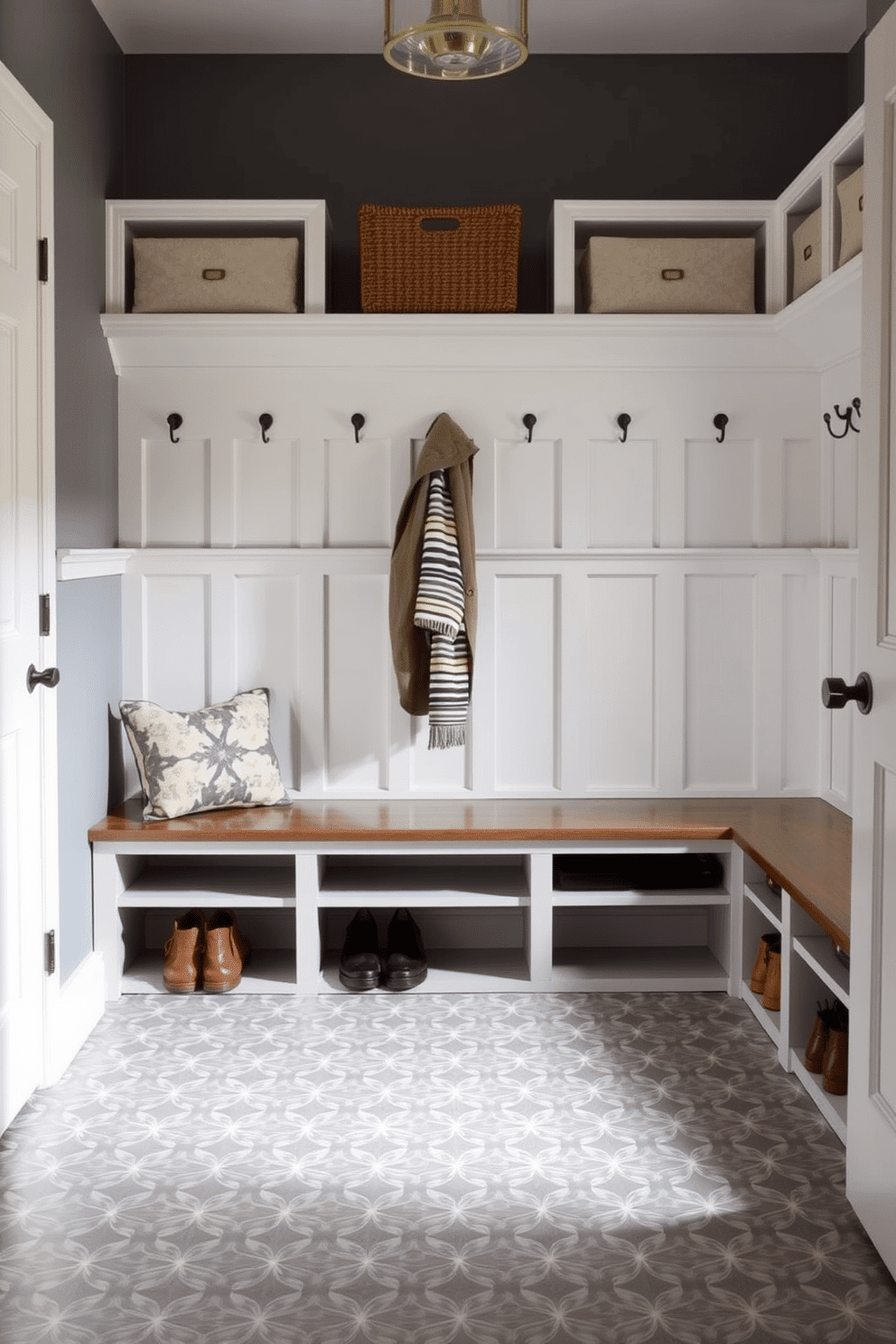 A stylish mudroom featuring gray patterned tile flooring that adds visual interest and texture. The space includes built-in benches with storage cubbies, and hooks for coats, creating an organized and inviting entryway.