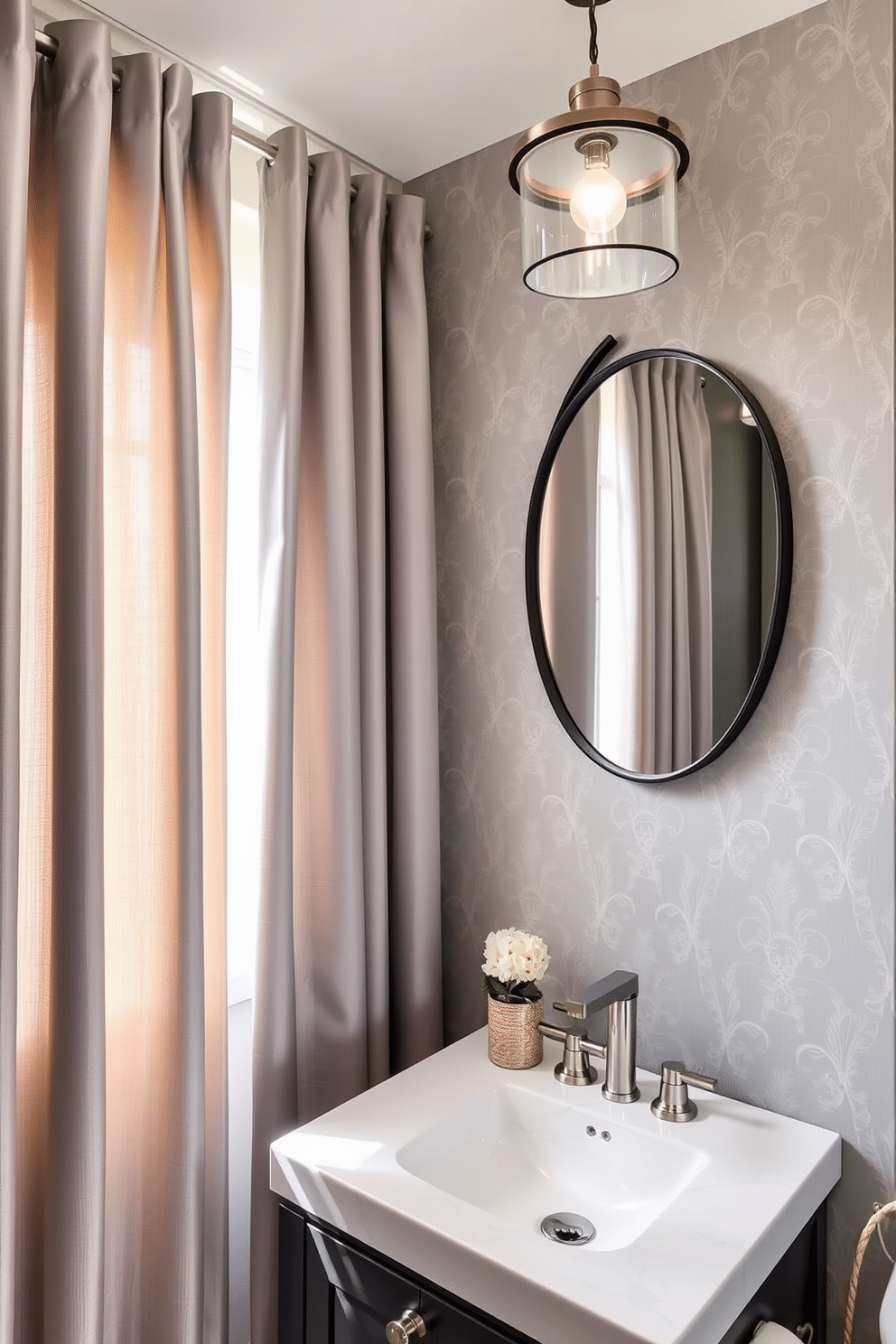 A stylish powder room featuring soft gray curtains that gently filter natural light, creating a serene atmosphere. The walls are adorned with elegant wallpaper in a subtle pattern, complementing the gray tones of the space. The vanity is a sleek design with a polished white sink and brushed nickel fixtures, providing a modern touch. A round mirror with a thin black frame hangs above the vanity, reflecting the soft lighting from a chic pendant light above.