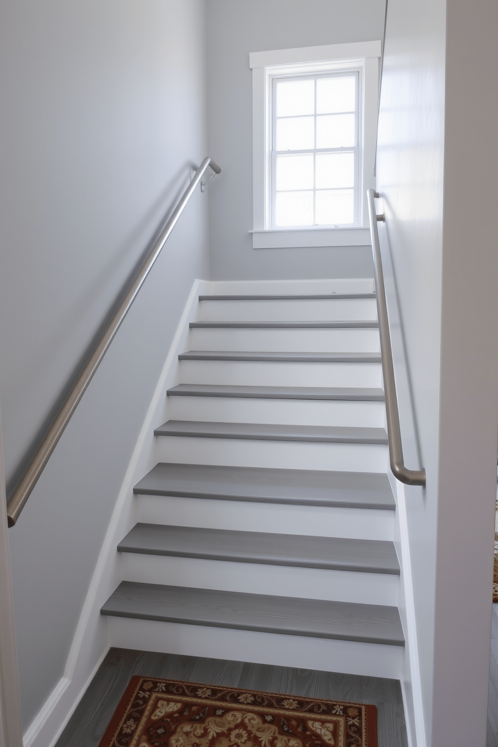 A stunning gray staircase features painted wooden treads with crisp white risers, creating a modern yet inviting atmosphere. The handrail is a sleek metal design, complementing the minimalist aesthetic while providing safety and style. Natural light floods the space through a nearby window, highlighting the subtle textures of the gray wood. Below, a decorative runner adds warmth and contrast, enhancing the overall elegance of the staircase design.