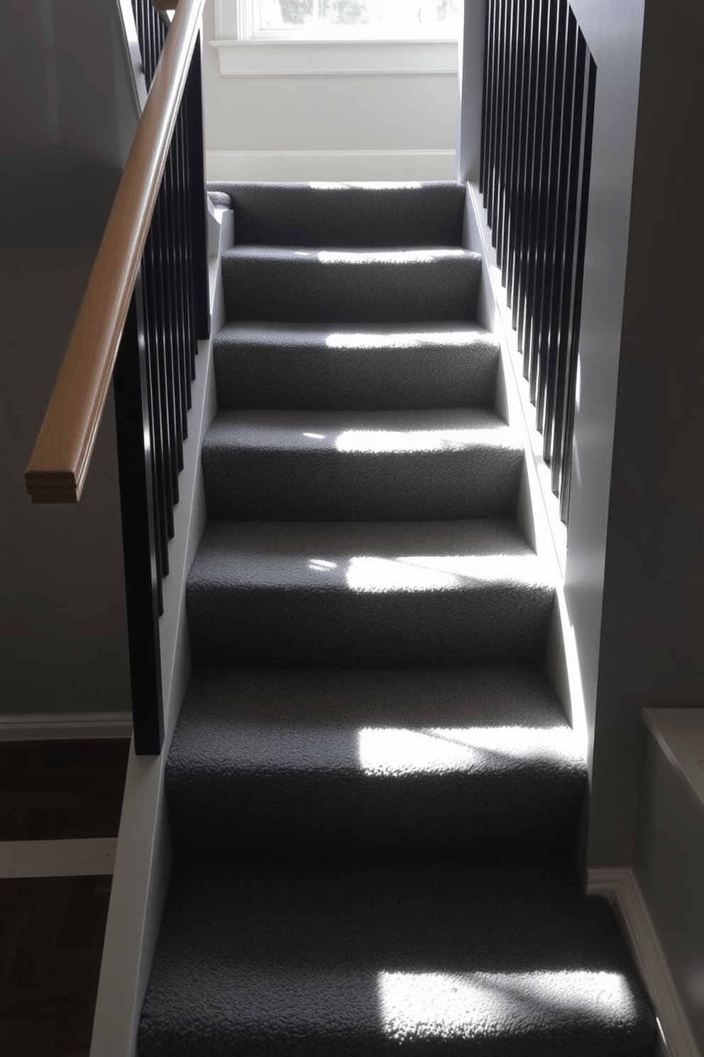 Charcoal gray carpeted stairs create a warm and inviting atmosphere, offering both comfort and style. The soft texture of the carpet enhances the overall aesthetic while providing a safe, non-slip surface for daily use. The staircase features sleek, modern railings that complement the gray tones, adding a touch of elegance to the design. Natural light floods in from a nearby window, casting gentle shadows that highlight the rich texture of the carpet.