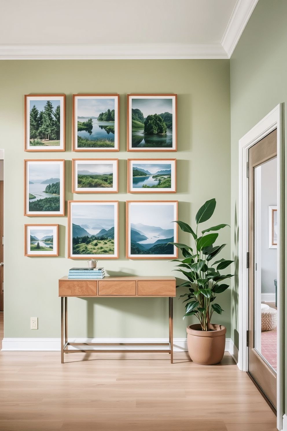 Framed nature photography adorns the walls of a spacious foyer, creating a serene and inviting atmosphere. The photographs feature lush landscapes and tranquil scenes, each framed in natural wood to complement the earthy tones of the space. The foyer boasts a soft green color palette, with a statement console table positioned against one wall. A large potted plant sits beside the table, adding a touch of life and freshness to the design.