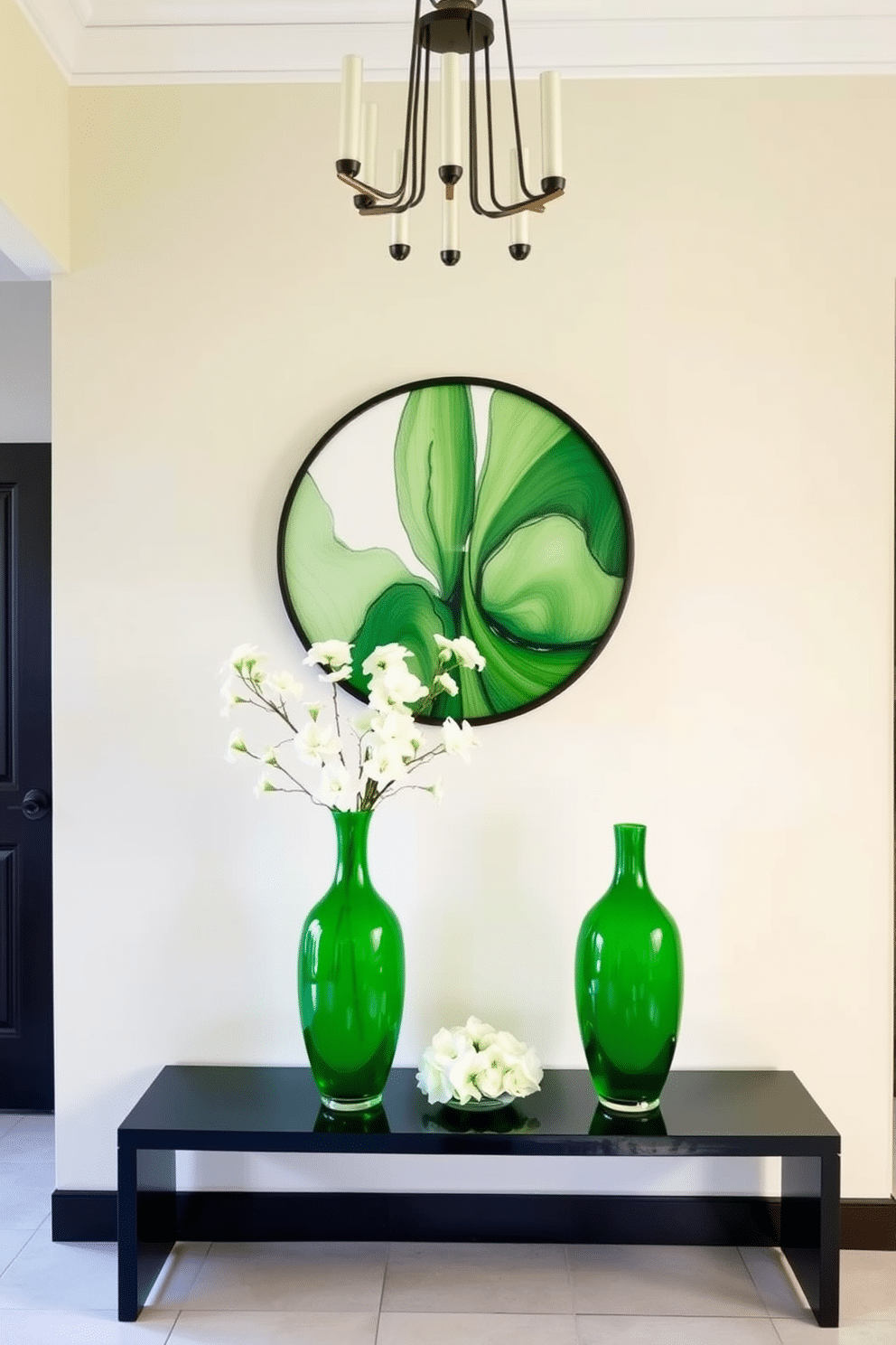 A stylish green foyer features a pair of elegant green vases positioned on a sleek console table, adorned with fresh white flowers. The walls are painted in a soft cream, contrasting beautifully with the rich green accents, while a modern chandelier hangs above, casting a warm glow over the space.