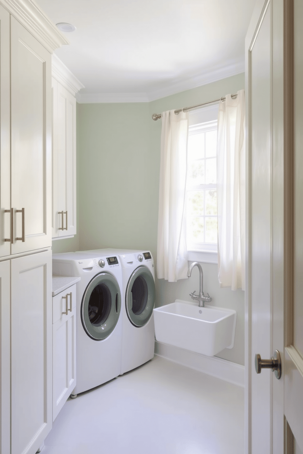 A serene laundry room infused with soft sage green walls that evoke a calming atmosphere. The space features white cabinetry with sleek handles, providing ample storage for laundry essentials. A large farmhouse-style sink sits prominently, complemented by a brushed nickel faucet. Natural light floods the room through a window adorned with light, airy curtains, enhancing the tranquil vibe.