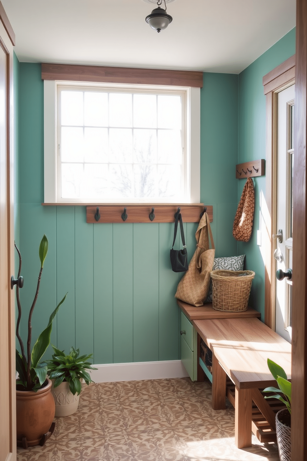 A welcoming mudroom featuring aqua green paint on the walls, complemented by rustic wood accents throughout. The space includes a wooden bench with storage underneath, and hooks for coats and bags are mounted on the wall above. Natural light floods in through a large window, illuminating a patterned tile floor that adds texture to the design. Potted plants sit in the corners, enhancing the earthy feel and bringing a touch of nature indoors.