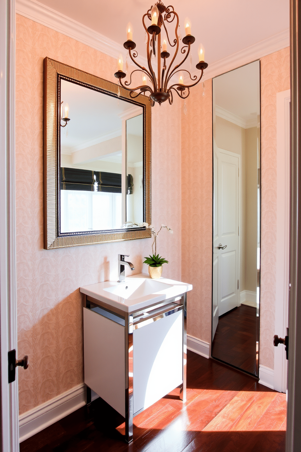 A stylish half bath featuring mirrored accents that enhance the sense of space and depth. The walls are adorned with a soft, neutral wallpaper, while a sleek, modern vanity with a polished chrome sink sits beneath a large, decorative mirror that reflects light beautifully. The flooring is a rich, dark hardwood, contrasting elegantly with the light-colored walls. An ornate chandelier hangs from the ceiling, casting a warm glow, and a small potted plant adds a touch of greenery to the design.