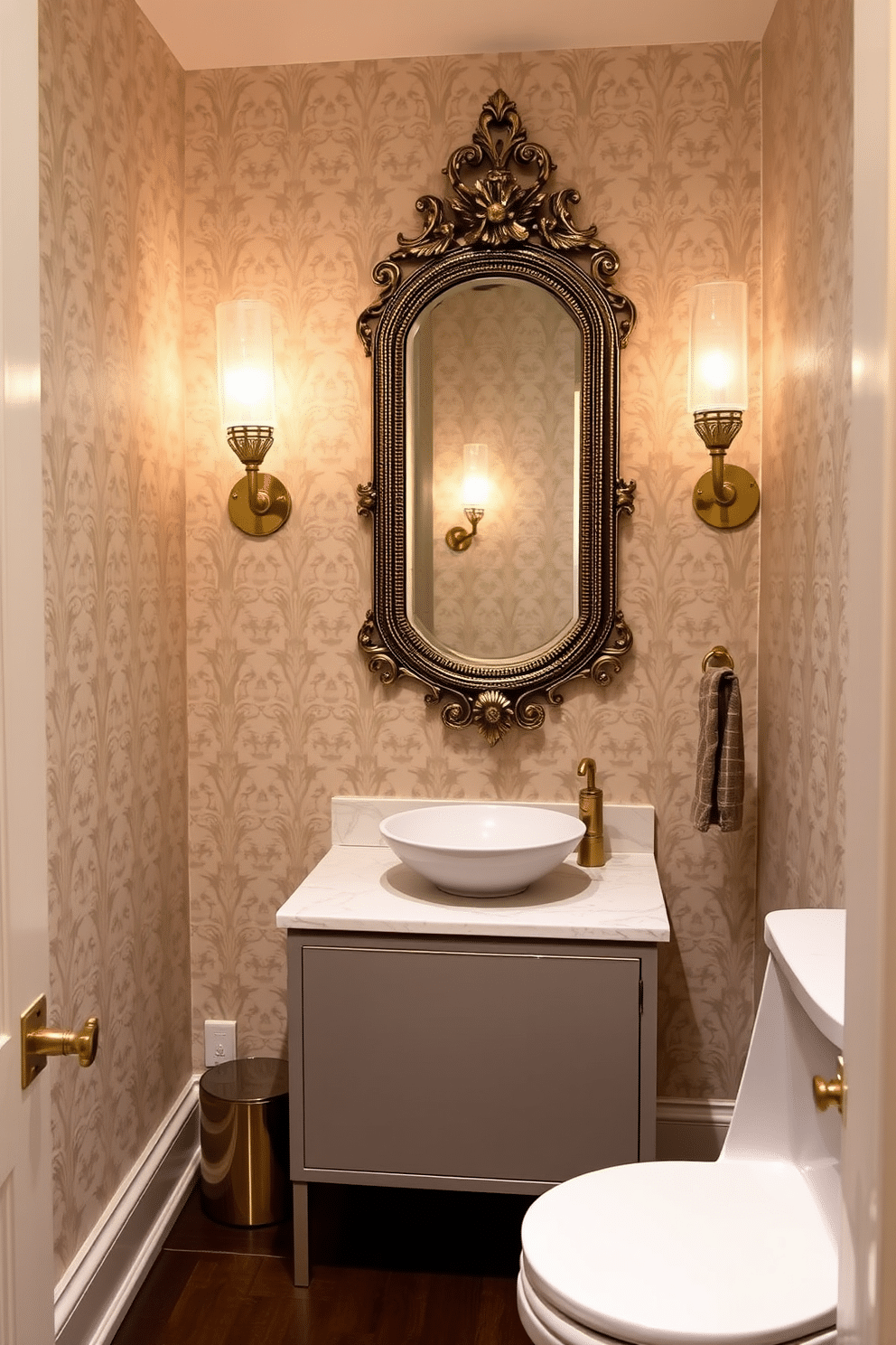 A half bath featuring elegant sconce lighting on either side of an ornate mirror, casting a warm glow across the space. The walls are adorned with a soft, neutral wallpaper, while the floor is finished with dark hardwood for a rich contrast. The vanity is a sleek, modern design with a polished marble top and a stylish vessel sink. Accents of gold in the fixtures and decorative elements enhance the luxurious feel of this intimate powder room.