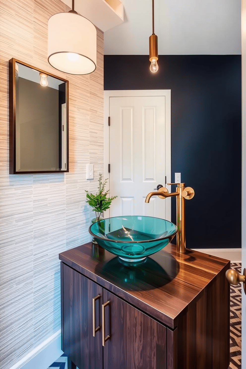 A unique vessel sink made of hand-blown glass sits atop a sleek, dark wood vanity, creating a stunning focal point in the half bath. The walls are adorned with a textured wallpaper in soft neutrals, and a stylish pendant light hangs above, casting a warm glow. The powder room features a contemporary design with geometric patterns on the floor and a bold accent wall painted in deep navy. A small potted plant adds a touch of greenery, while elegant brass fixtures complement the artistic sink design, enhancing the overall aesthetic.