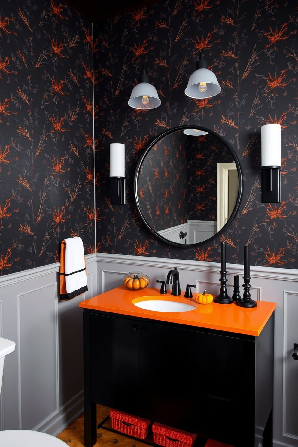 A striking Halloween-themed bathroom featuring a black and orange color scheme. The walls are adorned with black wallpaper that has subtle orange accents, creating a festive yet elegant atmosphere. A sleek black vanity with an orange countertop holds a large round mirror framed in black. Decorative elements like orange pumpkins and black candles are strategically placed around the sink area for a seasonal touch.