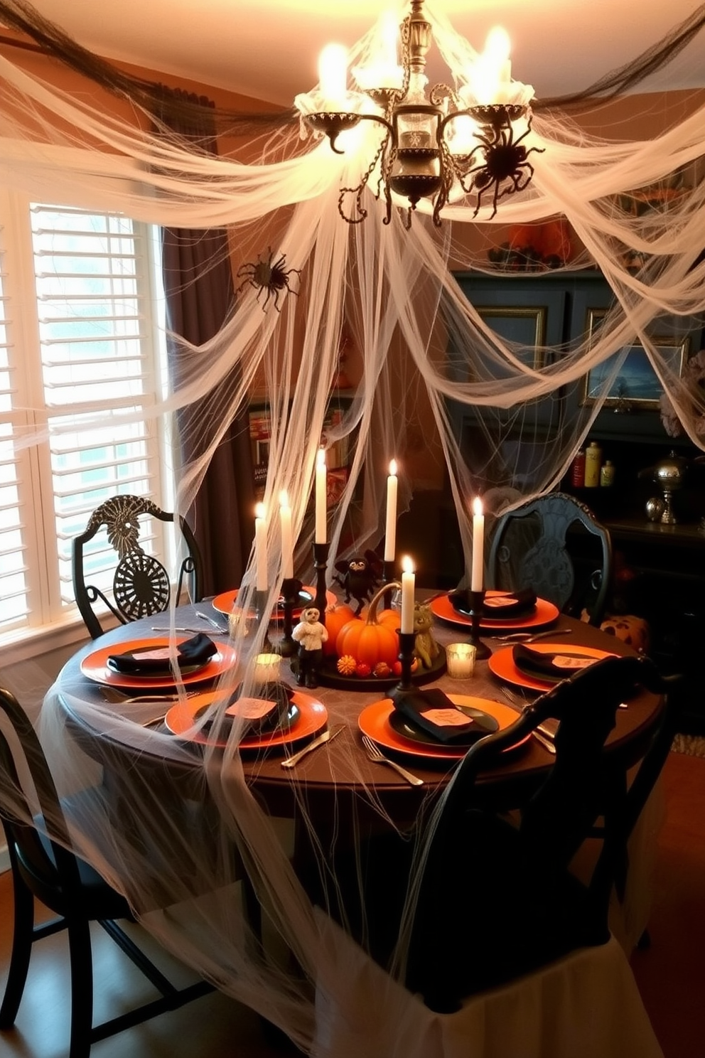 A whimsical Halloween dining room setting. Faux spiderwebs are draped across the dining table and chairs, creating an eerie yet festive atmosphere. The table is adorned with black and orange tableware, complemented by flickering candlelight. A centerpiece of miniature pumpkins and spooky figurines adds a playful touch to the decor.