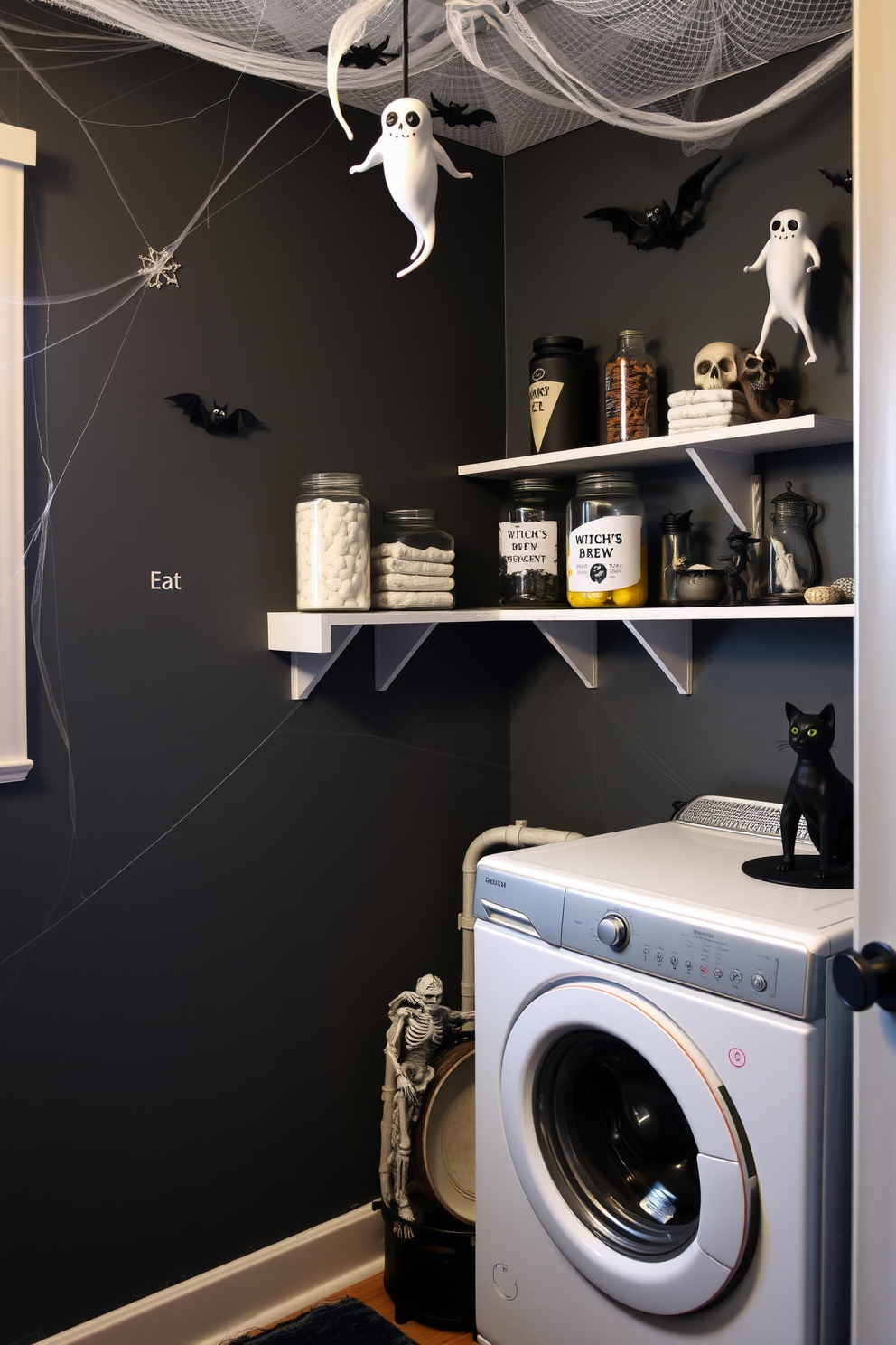 A spooky laundry room designed for Halloween. The walls are painted in dark grey with cobwebs in the corners and ghostly figures hanging from the ceiling. A vintage washing machine sits in the corner, surrounded by eerie decorations like skeletons and bats. A shelf above the machine displays creepy laundry-themed decor, including jars filled with 