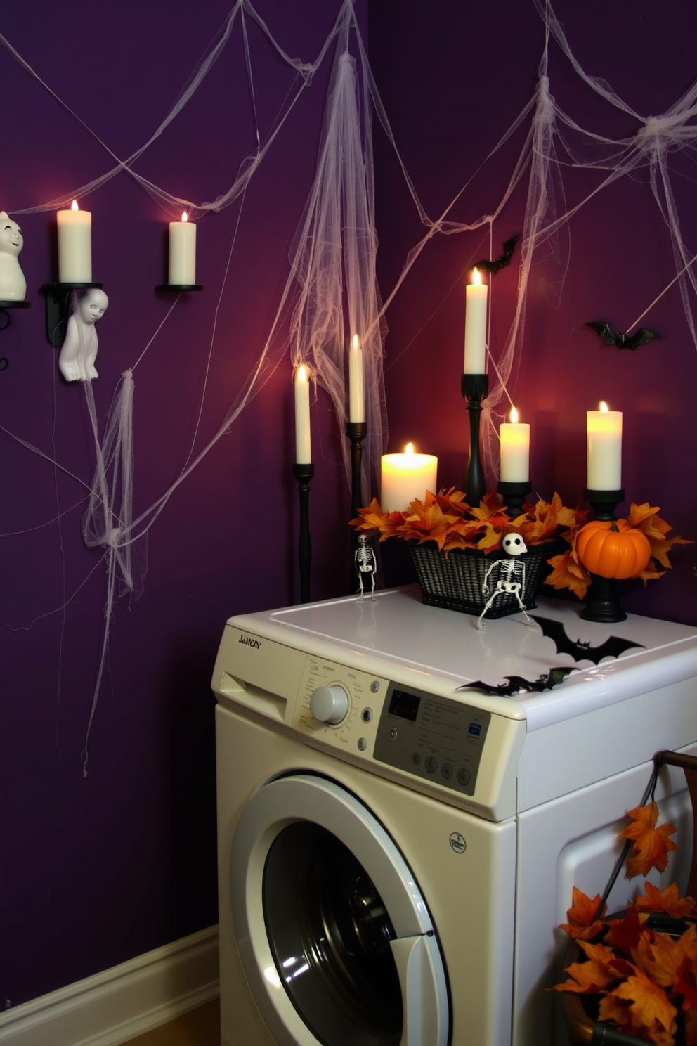 A spooky laundry room featuring themed candles in various shapes such as ghosts and pumpkins. The walls are painted in a deep purple hue, and cobwebs are artistically draped across the corners. A vintage washing machine sits against the wall, adorned with Halloween decorations like miniature skeletons and bats. A decorative basket filled with faux autumn leaves adds a festive touch to the space.