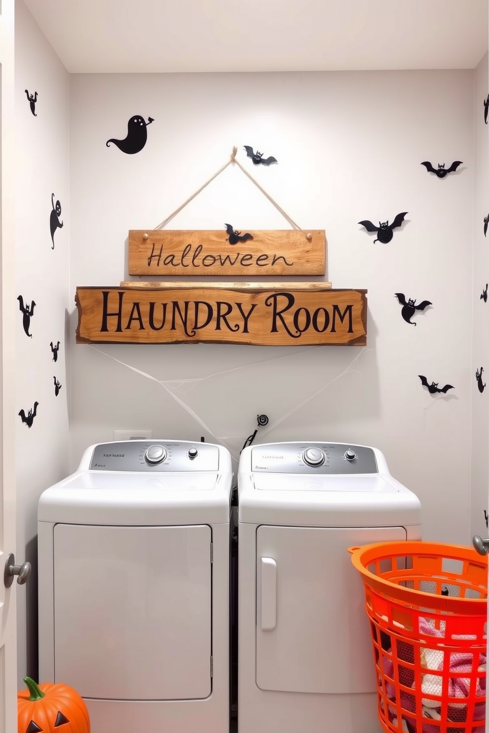 A whimsical laundry room featuring a Halloween theme. The walls are adorned with playful ghost and pumpkin decals, and a vibrant orange laundry basket sits in the corner. A rustic wooden sign hangs above the washer and dryer, reading Halloween Laundry Room in bold letters. Cobwebs and small decorative bats are strategically placed around the room for a festive touch.