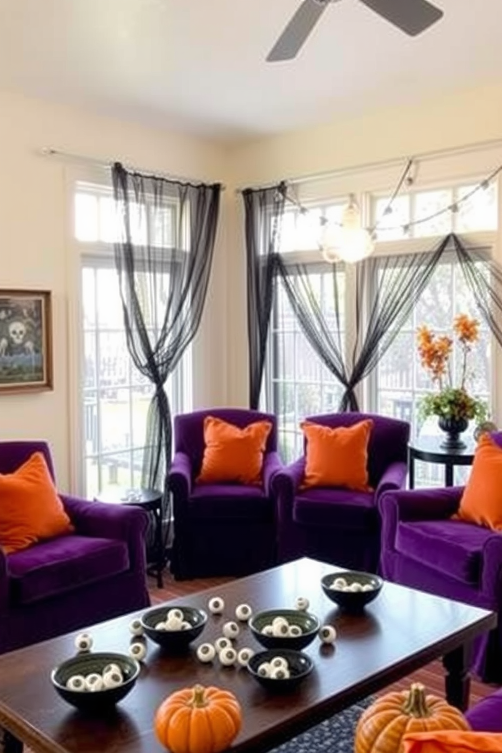 A whimsical sunroom featuring decorative bowls filled with faux eyeballs scattered across the coffee table. The walls are adorned with spooky artwork and the windows are draped with sheer black curtains allowing soft light to filter in. A cozy seating area includes plush chairs upholstered in deep purple fabric, accented with orange throw pillows. Pumpkins and seasonal foliage are arranged on the side tables, enhancing the Halloween theme while maintaining a cheerful atmosphere.