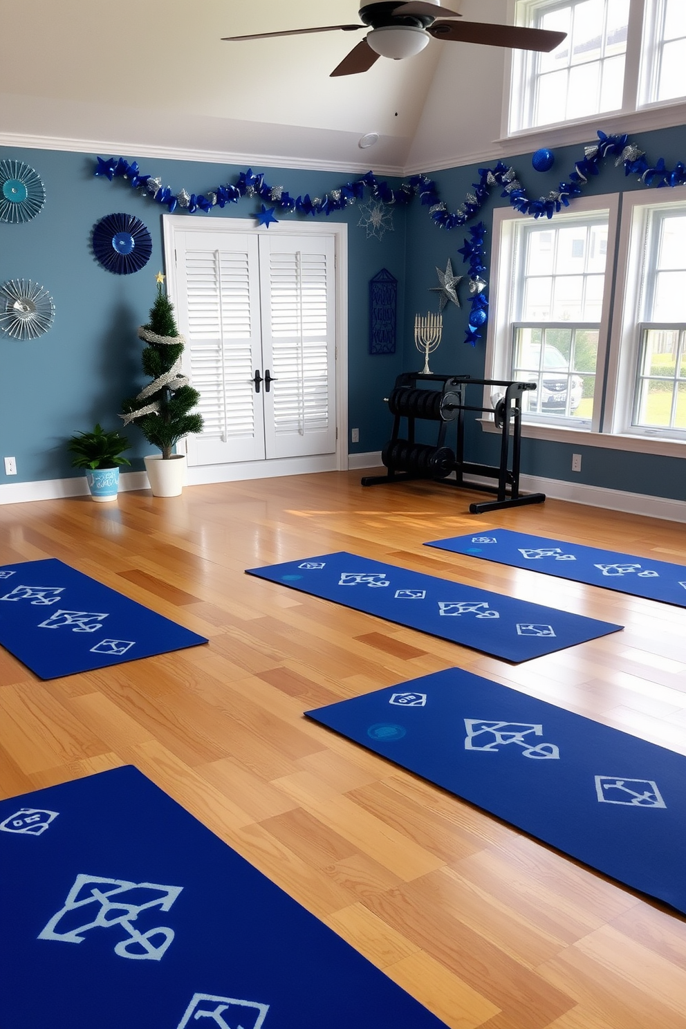 A serene home gym featuring dreidel-patterned yoga mats laid out on a polished wooden floor. The walls are adorned with festive Hanukkah decorations, including blue and silver accents, creating a vibrant yet calming atmosphere. Natural light floods the space through large windows, enhancing the cheerful ambiance. In one corner, a small potted menorah sits beside a set of weights, blending functionality with holiday spirit.