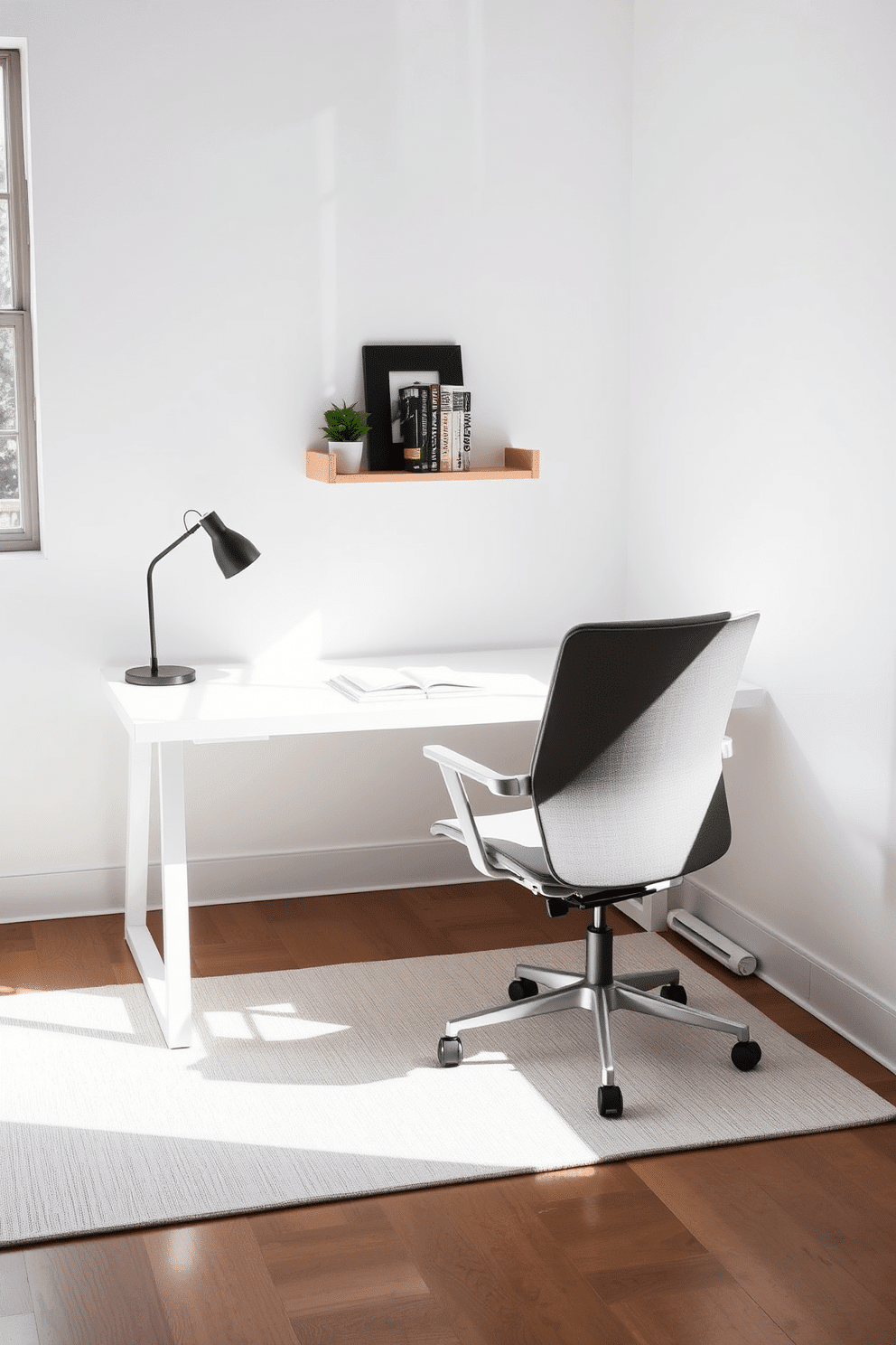 A minimalist home office features a sleek, white desk with clean lines, complemented by an ergonomic chair in soft gray fabric. The space is illuminated by natural light streaming through a large window, enhancing the calm and organized atmosphere. On the wall behind the desk, a simple shelf displays a few curated books and a small potted plant, adding a touch of greenery. The floor is adorned with a light-colored rug that provides warmth and texture, grounding the modern aesthetic.