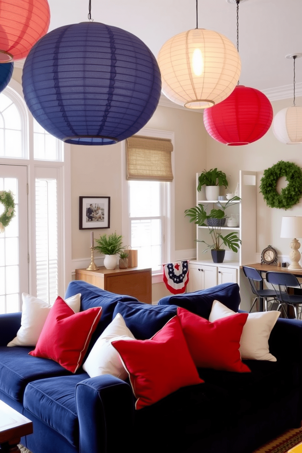 A cozy living room adorned with hanging paper lanterns in patriotic colors. The space features a plush navy blue sofa with red and white throw pillows, creating a festive atmosphere for Independence Day celebrations.