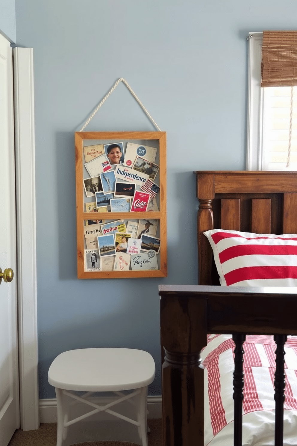 A cozy bedroom featuring a shadow box filled with vintage postcards celebrating Independence Day. The walls are painted in soft blue, and a rustic wooden bed frame is adorned with red and white striped bedding.