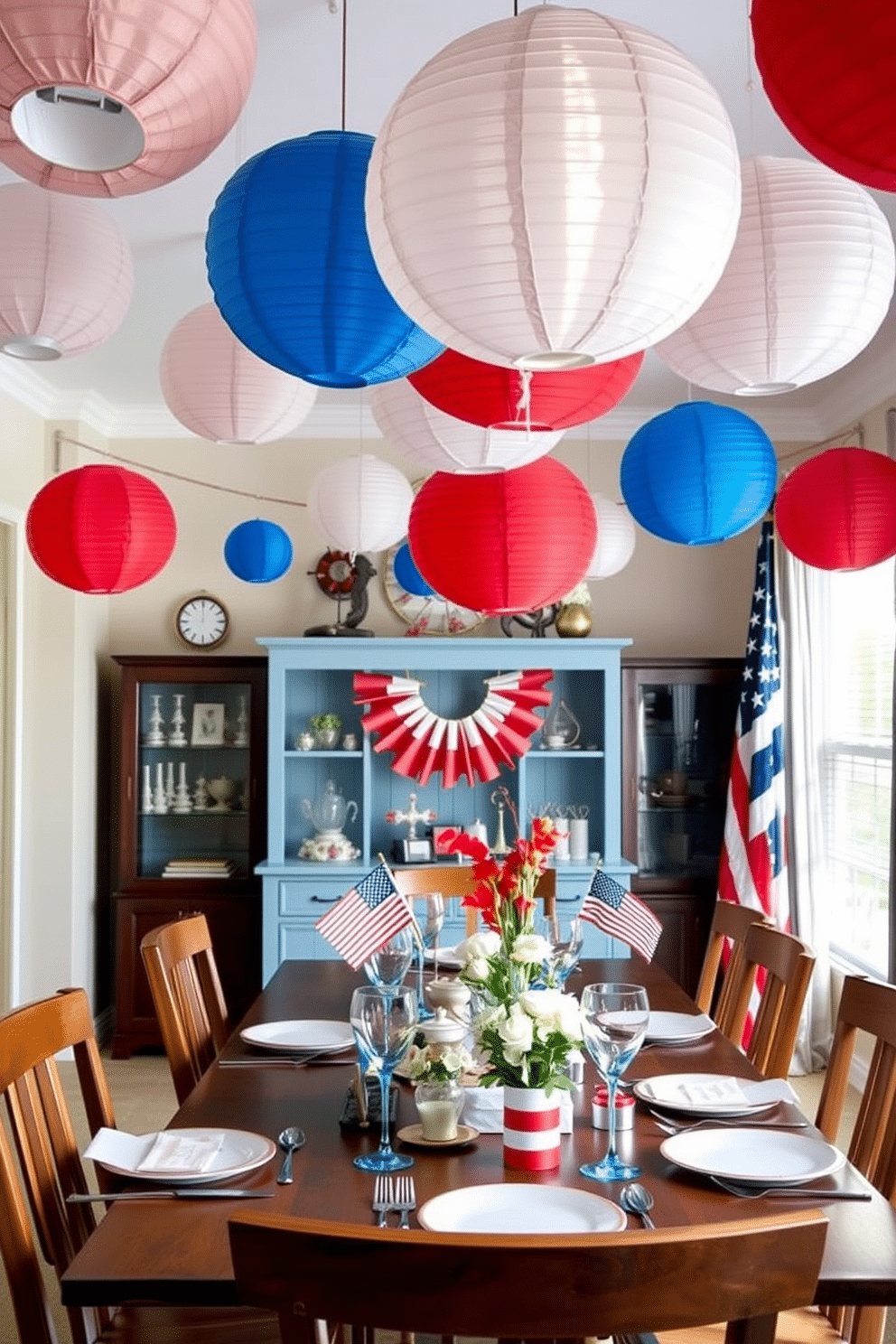 A festive dining room setting decorated for Independence Day. Colorful paper lanterns in red white and blue hang overhead creating a cheerful atmosphere.