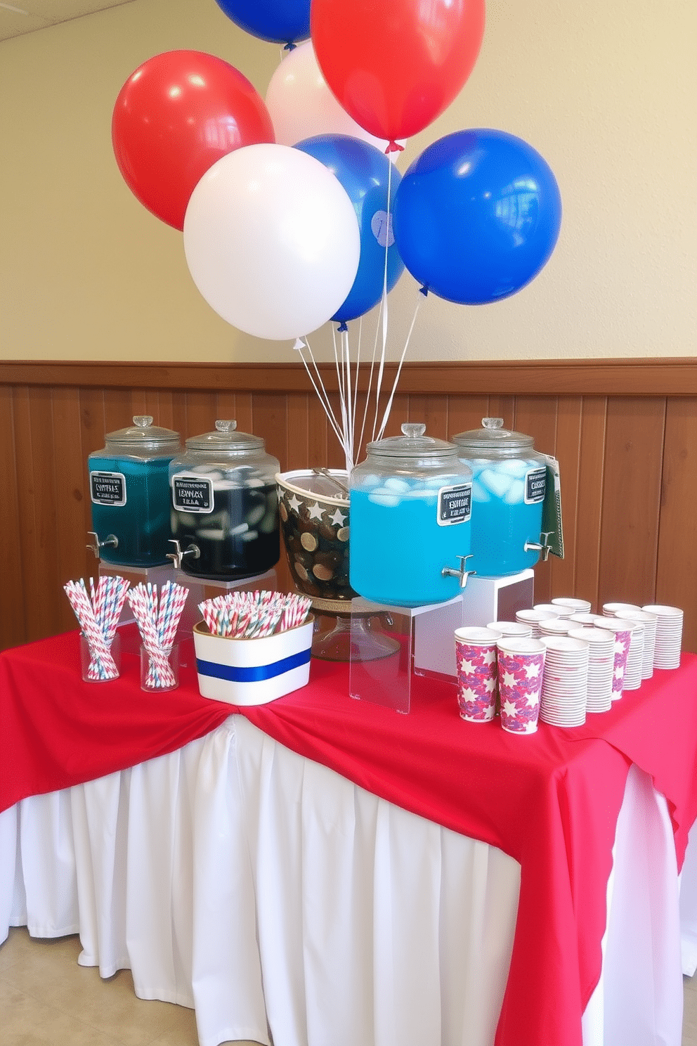 A festive drink station designed for Independence Day celebration. The station features a large table draped in a red and white striped tablecloth, adorned with an array of blue and white drink dispensers filled with lemonade and iced tea. Colorful paper straws and patriotic-themed cups are neatly arranged on the side. Red, white, and blue balloons float above the station, creating a cheerful atmosphere for guests to enjoy.