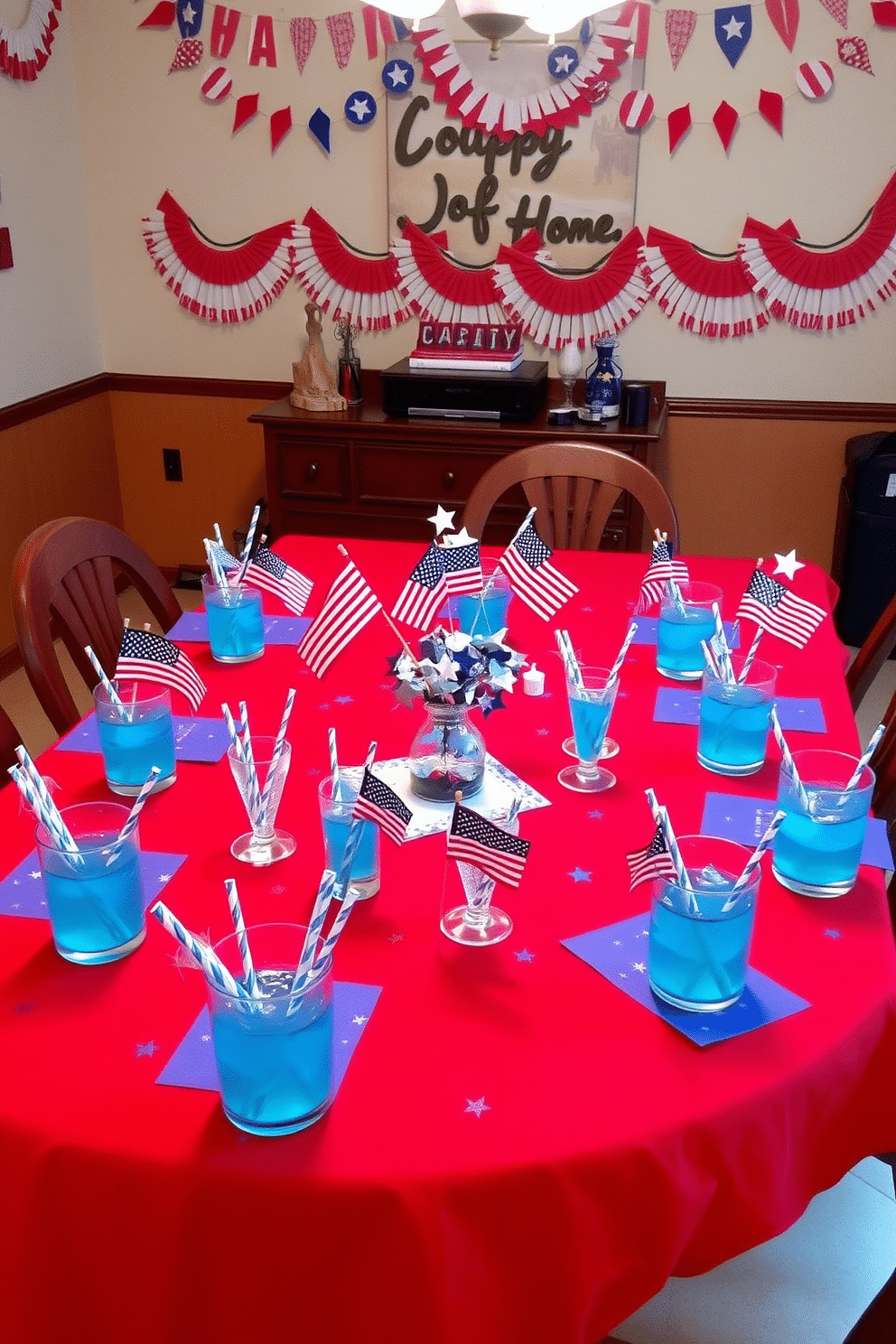 A festive dining room setting for Independence Day. The table is adorned with a vibrant red tablecloth, and scattered across it are blue and white straws in glasses filled with refreshing drinks. Decorative elements include small American flags and star-shaped centerpieces. The walls are decorated with red, white, and blue bunting, creating a joyful and patriotic atmosphere.