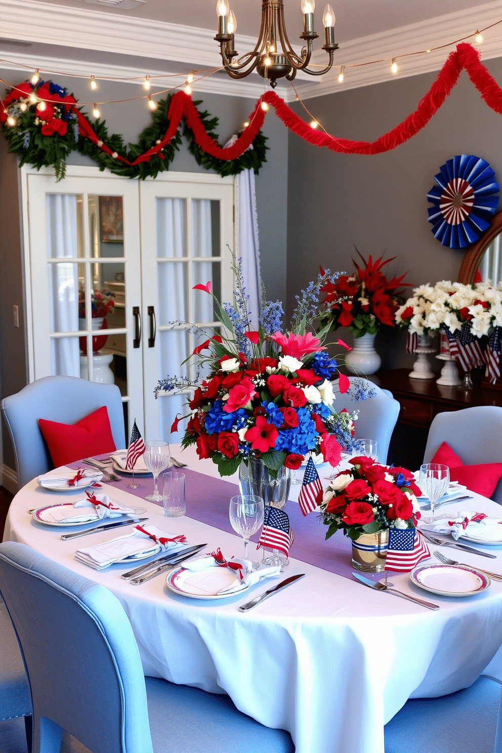 A festive dining room setting adorned with red blue and white floral arrangements. The table is elegantly set with a crisp white tablecloth, and vibrant flowers are displayed in a central vase, creating a patriotic ambiance. Surrounding the table are upholstered chairs in a soft blue fabric, complementing the decor. String lights hang overhead, adding a warm glow to the celebration, while decorative accents in red and white enhance the festive theme.