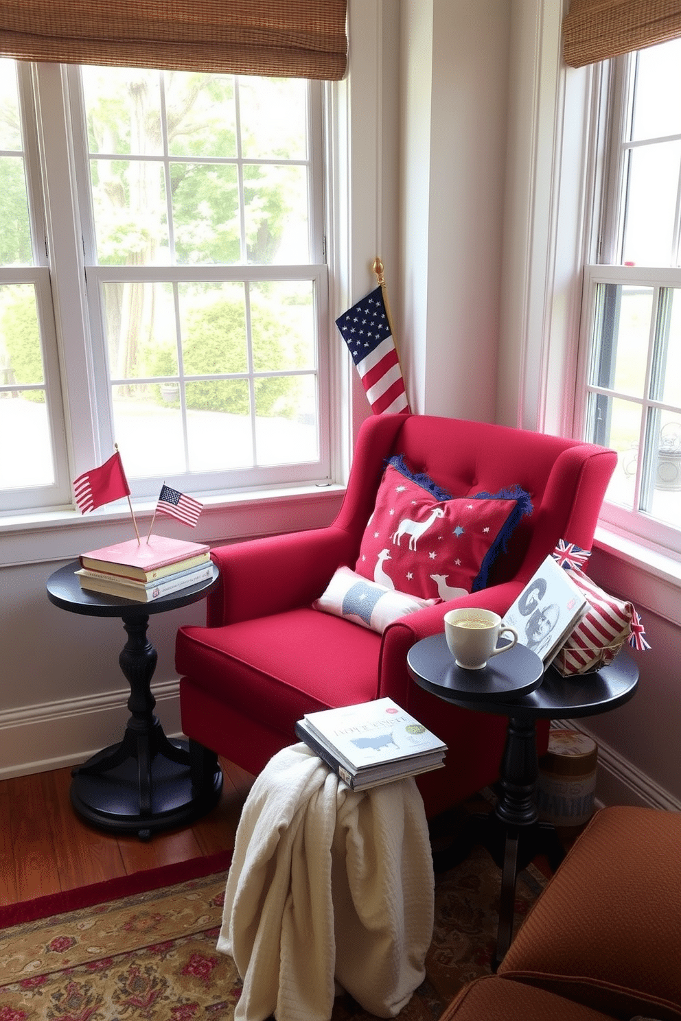 Cozy armchair with red upholstery. The armchair is positioned in a corner by a large window, allowing natural light to stream in. A small side table is placed next to the armchair, holding a stack of books and a steaming cup of tea. Patriotic decorations, such as small flags and red, white, and blue throw pillows, enhance the Independence Day theme.