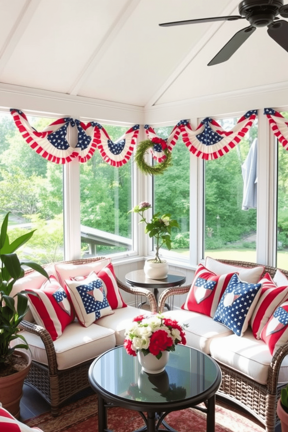 A sunroom decorated for Independence Day features a comfortable seating area adorned with red, white, and blue throw pillows. The natural light floods the space, highlighting a cheerful atmosphere perfect for celebrating the holiday.