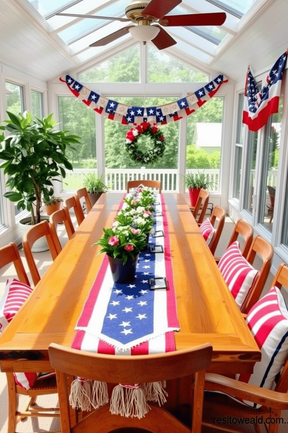 A cheerful sunroom decorated for Independence Day features a long wooden dining table adorned with stars and stripes table runners. Bright red, white, and blue cushions are placed on the chairs, and potted plants add a touch of greenery to the space.