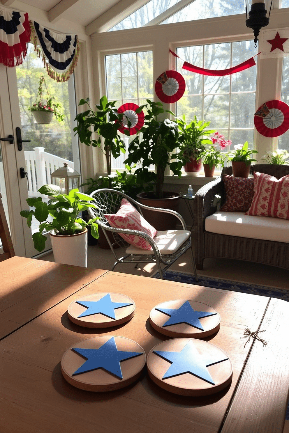 Themed coasters with star designs are placed on a rustic wooden table in the sunroom. Sunlight streams through large windows, illuminating the vibrant colors of red, white, and blue in the decor. Independence Day decorations adorn the sunroom, featuring festive bunting and potted plants. A cozy seating area invites guests to relax and enjoy the celebratory atmosphere.